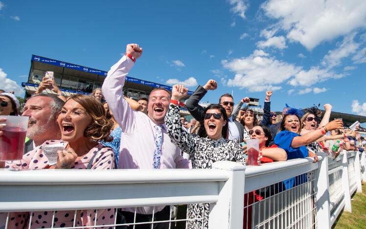 The crowd at the trackside at Newcastle Races going crazy cheering for their horses.