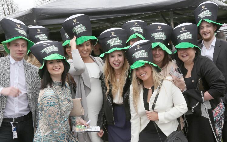 A large group of race goers in St Patricks Day hats.