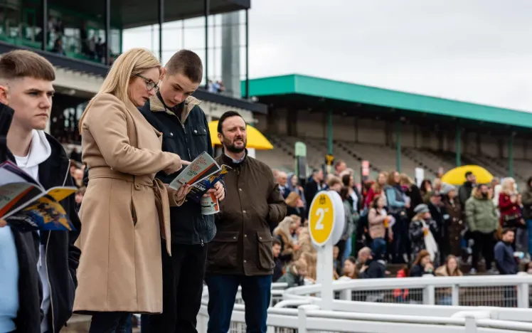 A couple study the racecard from the grandstand at Newcastle